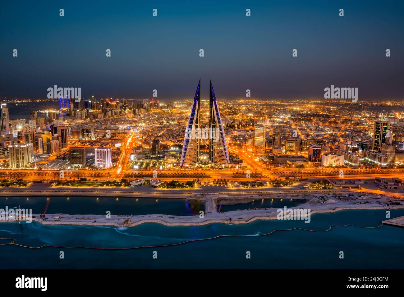 Manama, Bahrain bei Sonnenuntergang mit Megacity-Skyline, Wolkenkratzern, moderner Architektur, leuchtenden Lichtern der Stadt und urbanem Golf-Flair Stockfoto