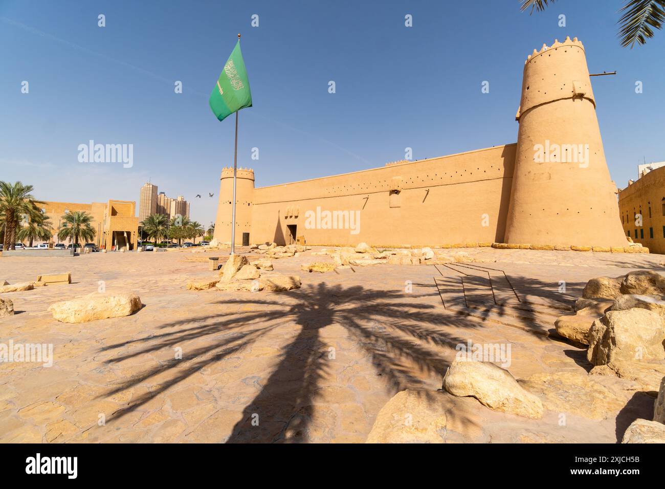 Riad, Saudi-Arabien: Saudische Nationalflagge fliegt an einem sonnigen Tag über dem berühmten Masmak-Fort in der Altstadt von Riad in der Hauptstadt Saudi-Arabiens. Stockfoto