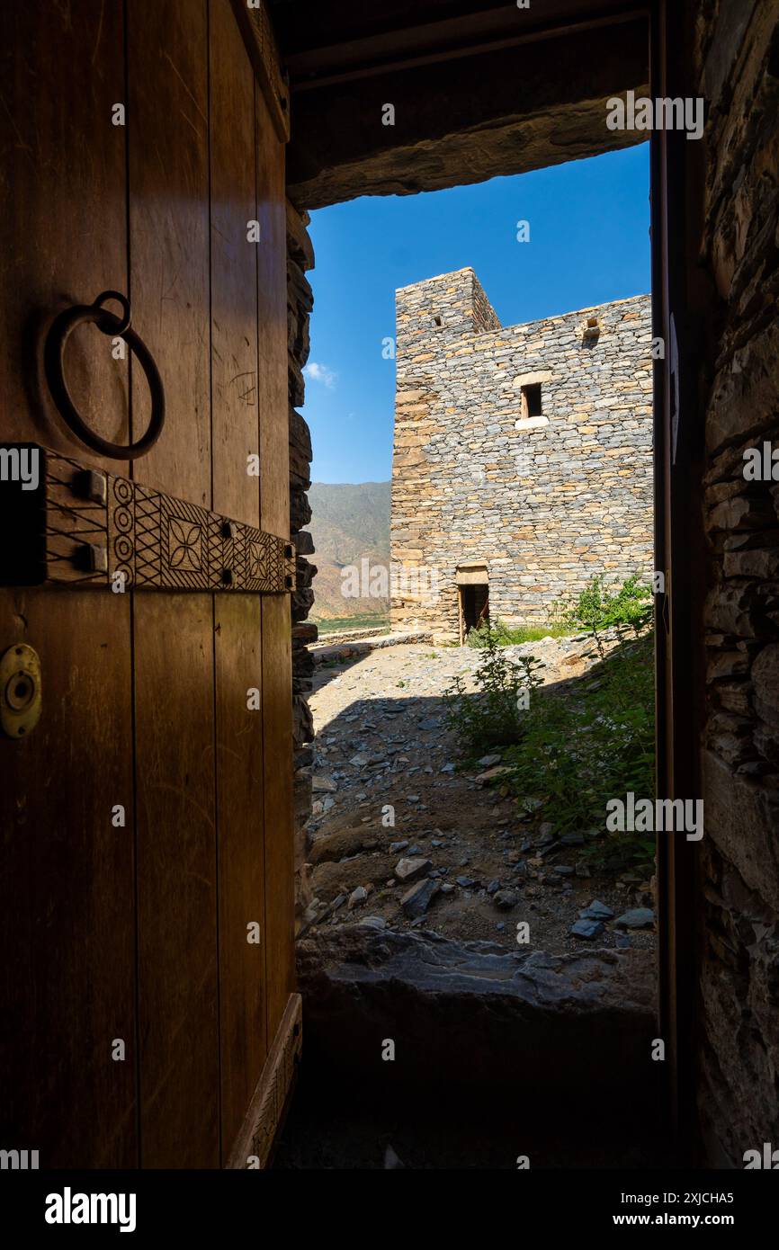 Al Bahah, Saudi-Arabien: Ein Blick durch eine alte Holztür auf das antike Dorf Thee Ain oder Zee Ain in Saudi-Arabien in der Nähe von Dschidda. Stockfoto