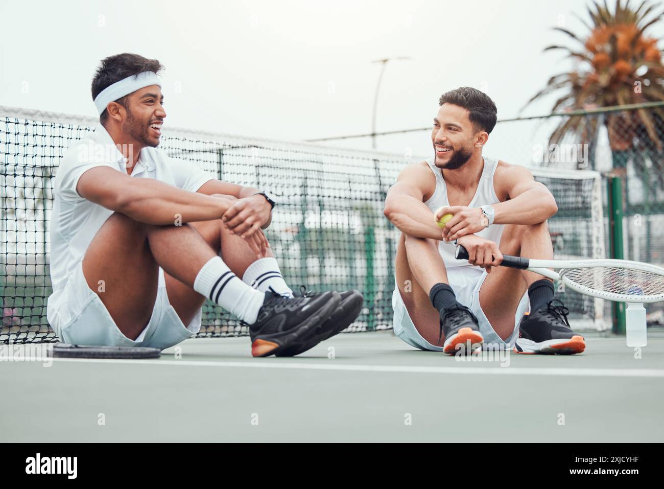 Freunde, Tennis und Pause mit Schläger, reden und glücklich für Match mit Ausrüstung, Platz und Fitness für Sport. Outdoor, Team und Spiel für Menschen Stockfoto