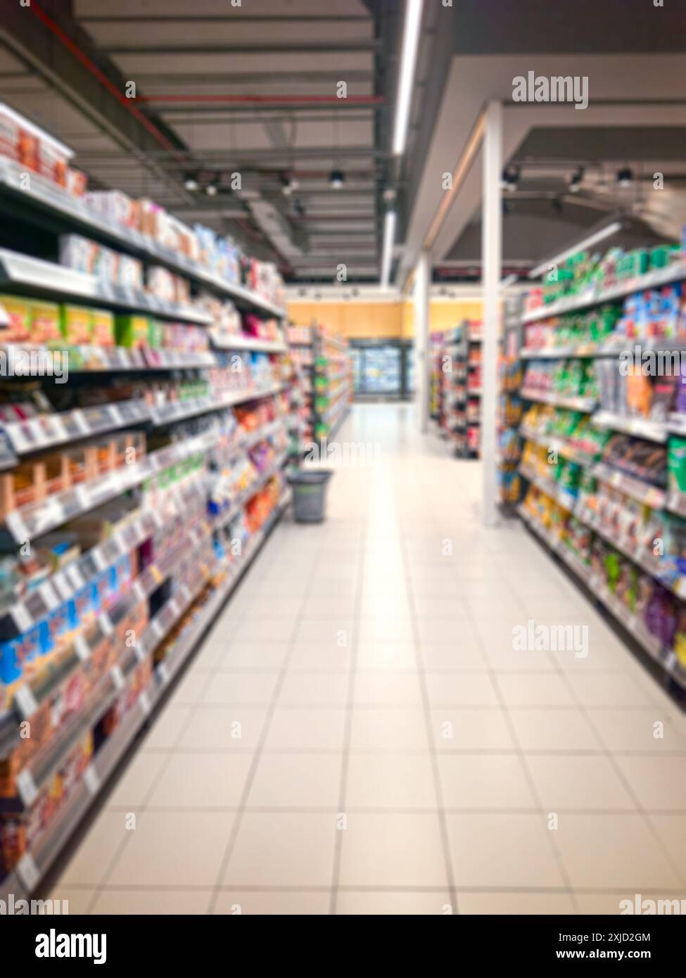 Supermarktgang mit bunten Regalen. Abstrakte Unschärfe als Hintergrund. Stockfoto
