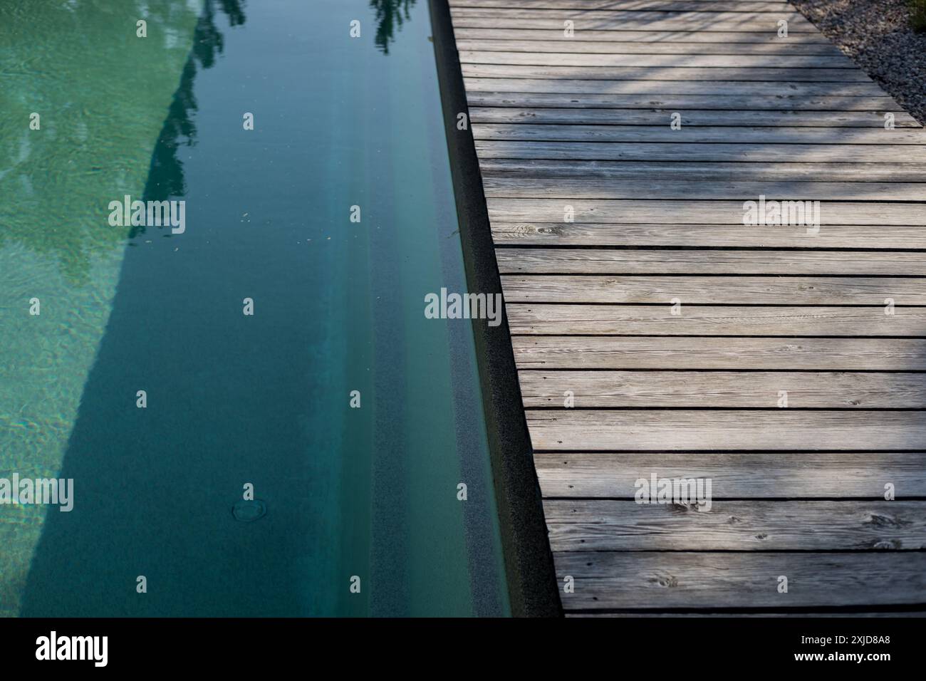 Holzrand des privaten Swimmingpools mit Wasseroberfläche Stockfoto