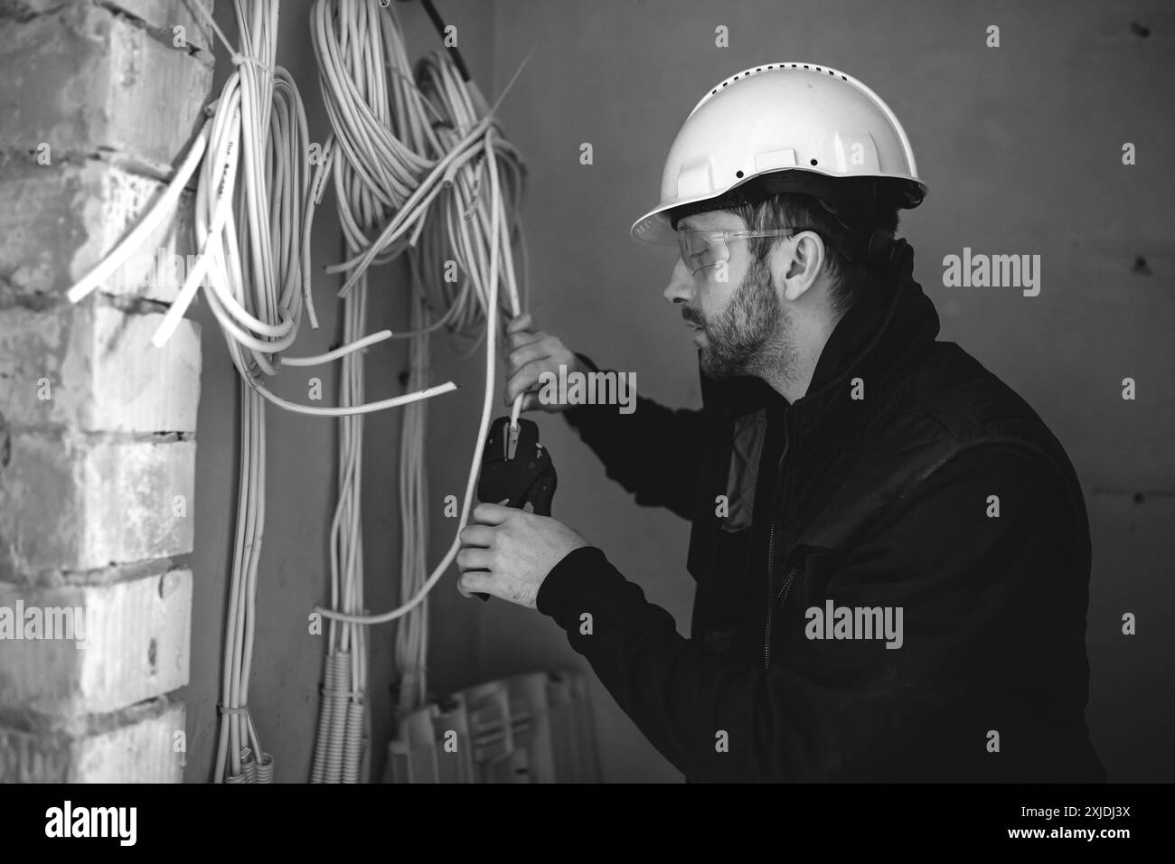 Schwarzweiß-Foto mit Elektriker bei der Arbeit. Stockfoto