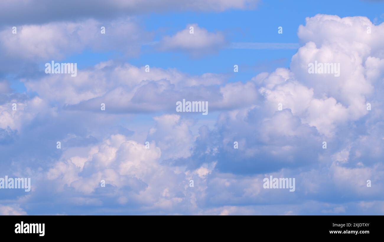 Zeitraffer. Dramatisch bewegte weiße Kumulus- und Zirrocumulus-Wolken oder eine flauschige Wolkenlandschaft am wunderschönen sonnigen blauen Himmel. Stockfoto