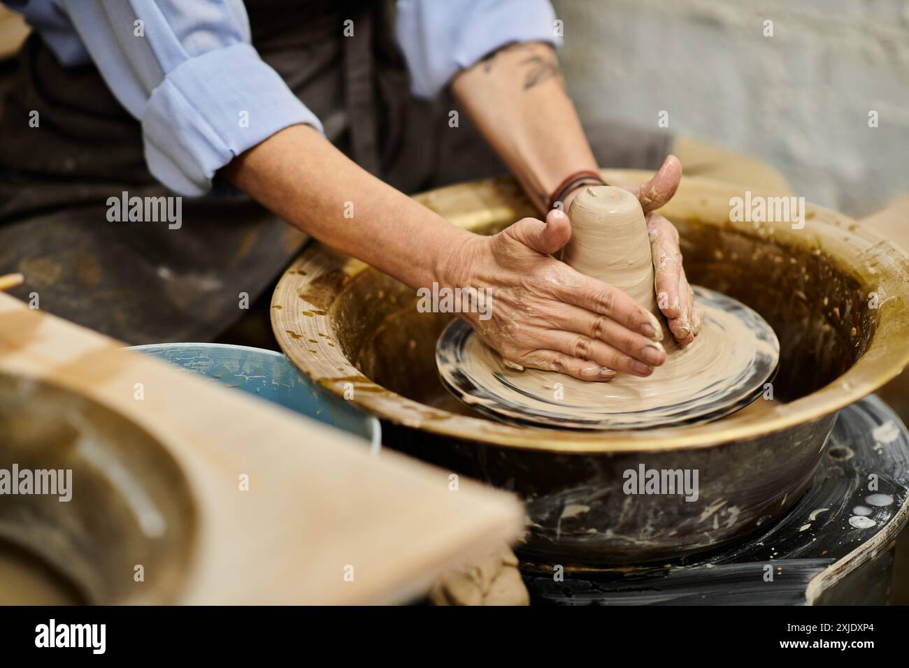 Eine Nahaufnahme einer Frauenhände, die Ton auf einem Keramikrad Formen. Stockfoto