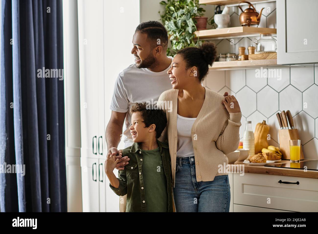 Ein Mann, eine Frau und ein Kind teilen einen Moment der Zweisamkeit in einer gemütlichen Küche. Stockfoto