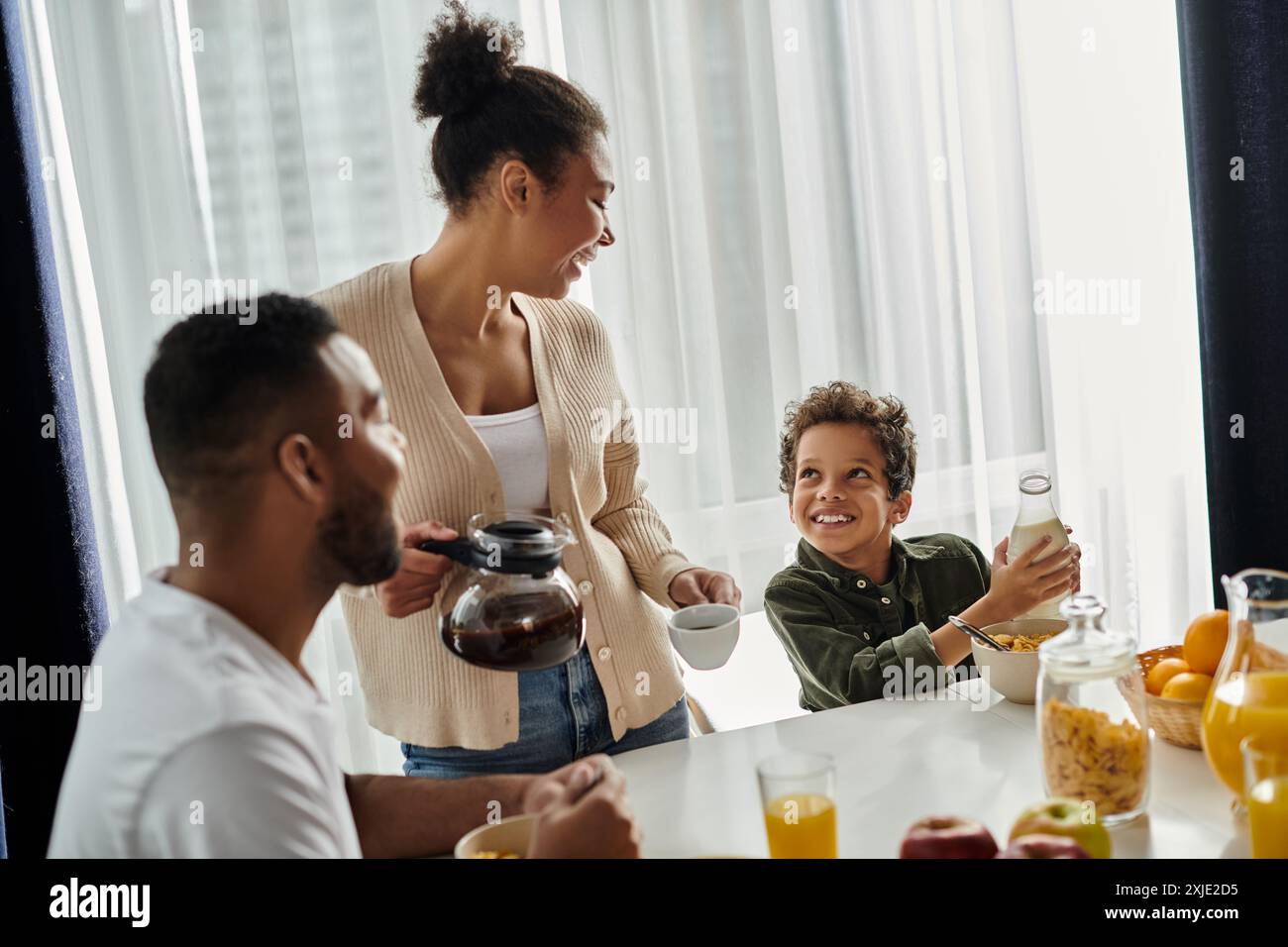 Eine liebevolle afroamerikanische Familie, die gemeinsam am Tisch speisen kann. Stockfoto