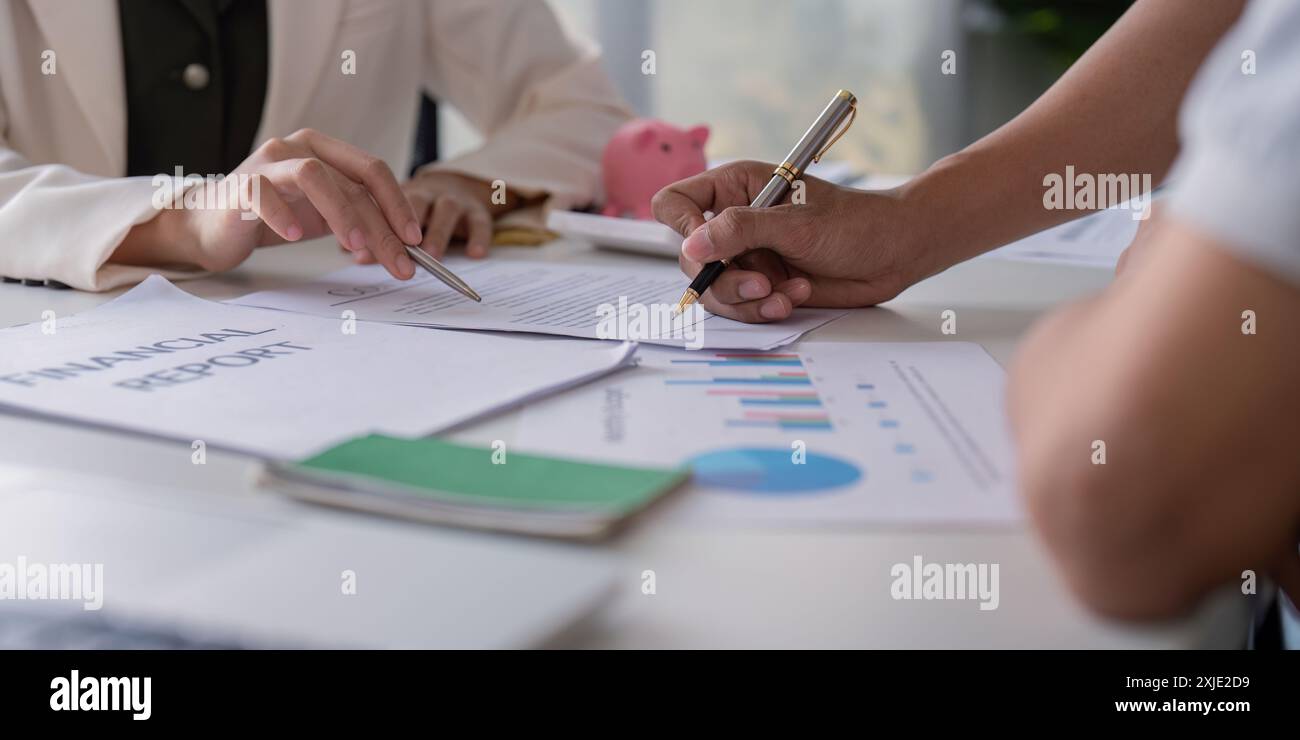 Schwulenpaar plant Finanzen zu Hause zusammen mit Finanzbericht und Diagrammen auf dem Tisch Stockfoto