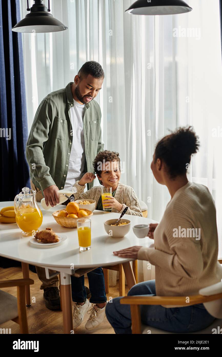 Afroamerikaner, Frau und Kind, sitzen glücklich an einem Tisch. Stockfoto