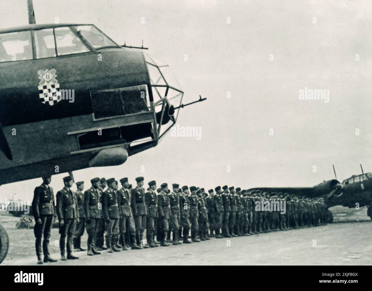 Ein Foto zeigt kroatische Soldaten, die während der Operation Barbarossa 1941 in Formation auf einem Flugplatz stehen. Nach der Invasion der Achsenmächte in Jugoslawien schloss sich der neu gegründete unabhängige Staat Kroatien dem Nazi-Deutschland an. Kroatische Truppen, die sowohl durch ideologische Ausrichtung als auch durch Eigeninteressen motiviert waren, unterstützten den deutschen Vormarsch gegen die sowjetischen Truppen an der Ostfront. Stockfoto