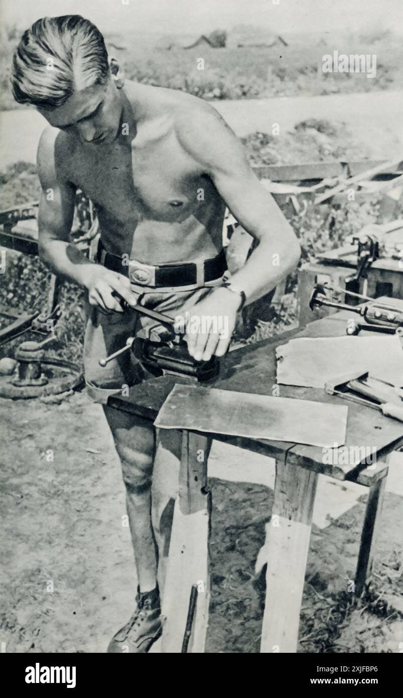 Ein Foto zeigt einen Soldaten der Luftwaffe, der während des Zweiten Weltkriegs an einem Basisarbeitsplatz kleine Stöße auf Rumpf, Flügel oder Heck eines Flugzeugs repariert. 1941, während der Operation Barbarossa, war es entscheidend, dass die Flugzeuge gut erhalten wurden, während Deutschland weiter an die Ostfront vordrang. Stockfoto