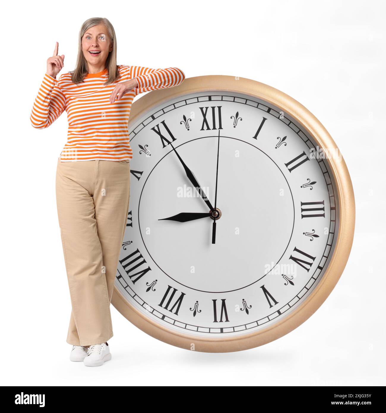 Reife Frau und große Uhr auf weißem Hintergrund Stockfoto