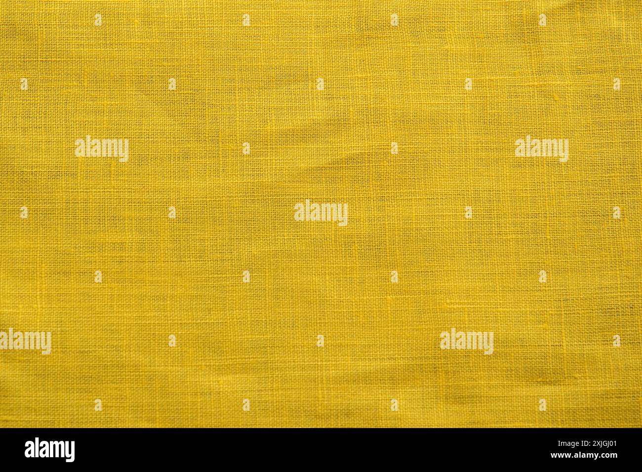 Die Textur der gelben Leinenbettnaht als textiler Hintergrund Stockfoto