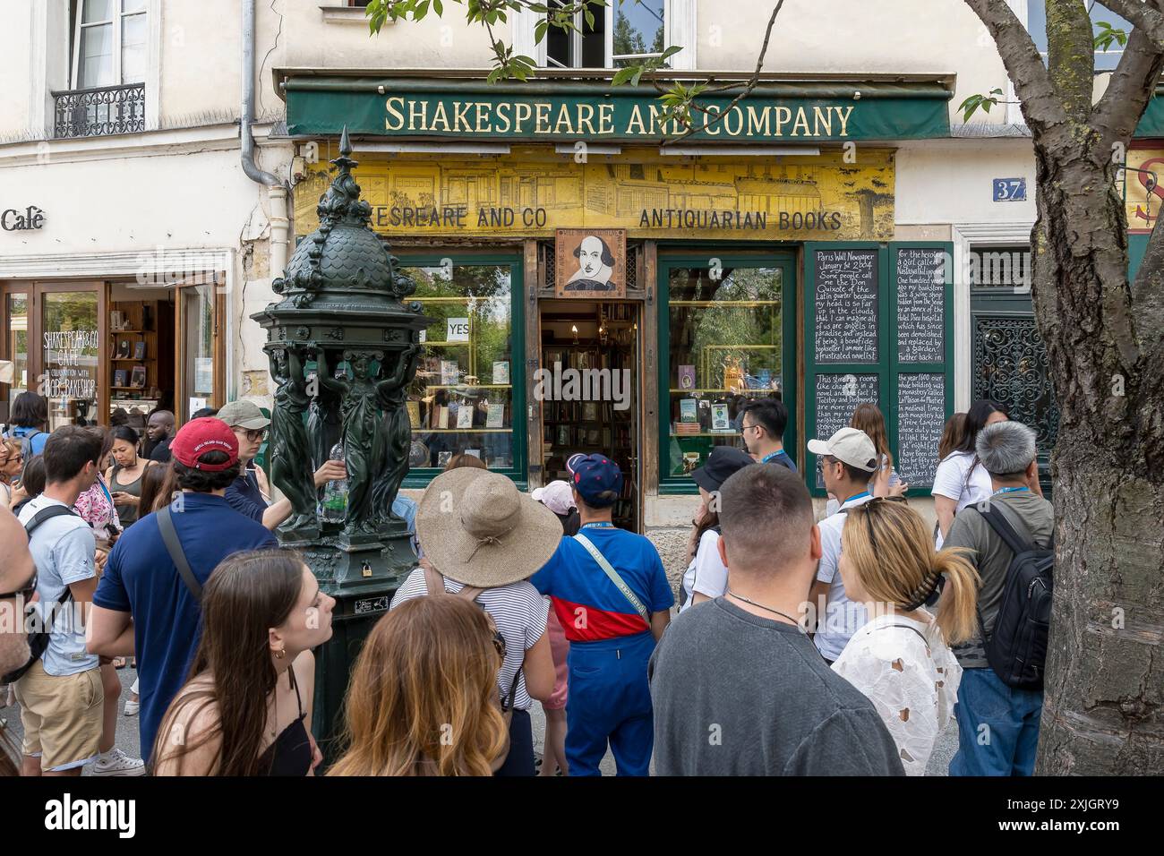 Leute stehen an, um die berühmte alte Buchhandlung Shakespeare and Company auf der linken Seite im 5. Arrondissement von Paris, Frankreich, Europa, EU zu betreten Stockfoto