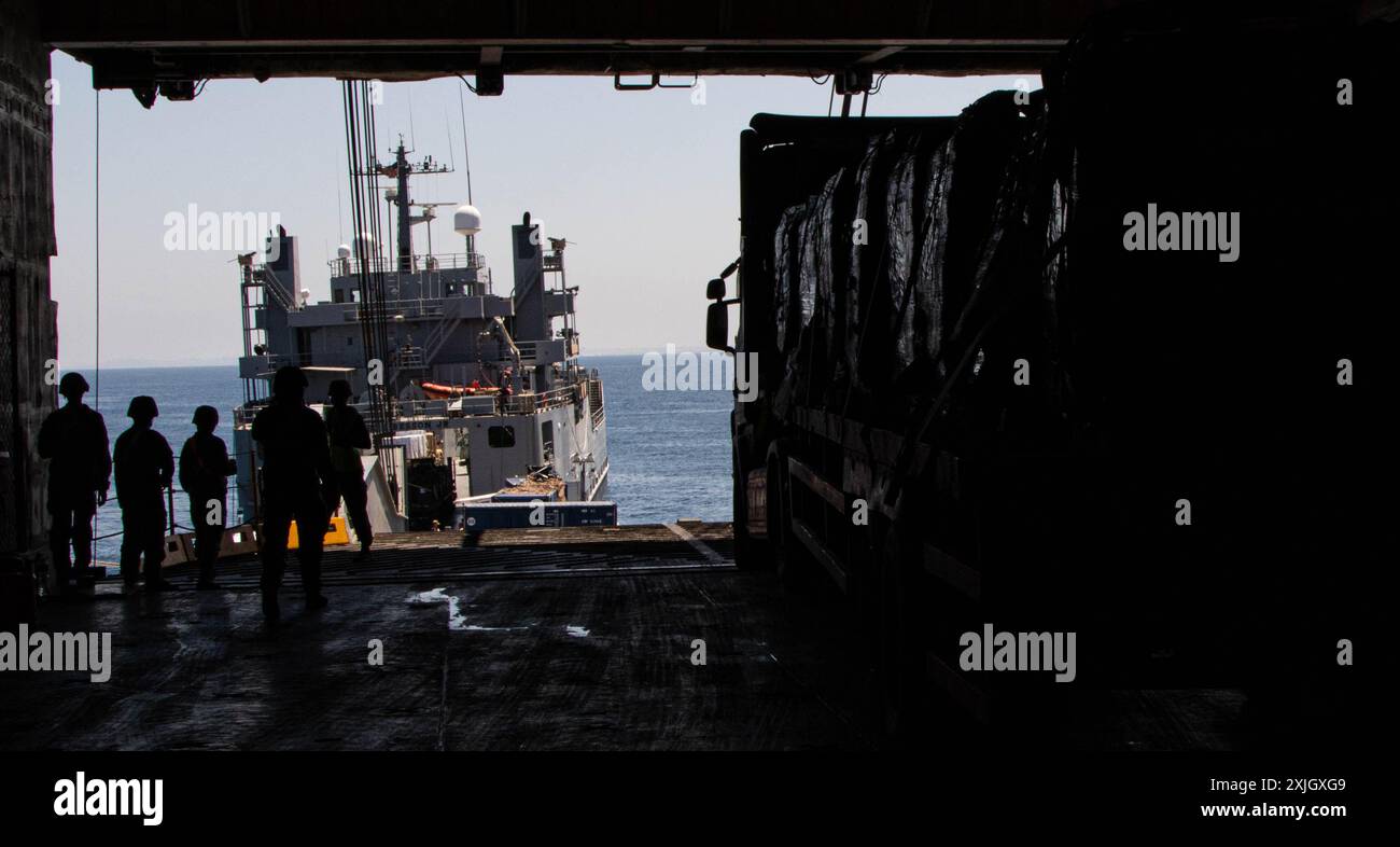 Soldaten der US-Armee, die der 7. Transportbrigade (Expeditionary) zugewiesen sind, und Seeleute der US-Navy, die dem Amphibious Construction Battalion 1 zugewiesen sind, leiten vom DoD beauftragte Fahrer, die humanitäre Hilfe vom MV Roy P. Benavidez zur Roll-on Roll-off Distribution Facility (RRDF) und zum US-Army-Schiff LSV-1 transportieren, 11. Juni 2024. vor der Küste von Gaza. Nach einer vorübergehenden Aussetzung aufgrund schwerer seestaaten nahm der vorübergehende Pier, Teil der gemeinsamen Logistik über die Küste, die internationale humanitäre Hilfe für die Bürger Gazas wieder auf. (Foto der US-Armee vom Stab Stockfoto