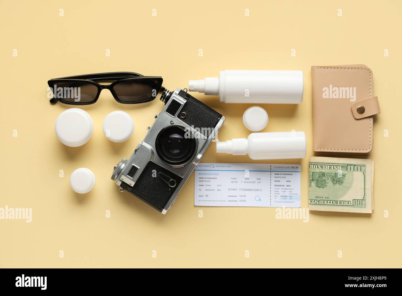 Komposition mit kosmetischem Reiseset, weiblichen Strandaccessoires, Ticket und Fotokamera auf farbigem Hintergrund Stockfoto