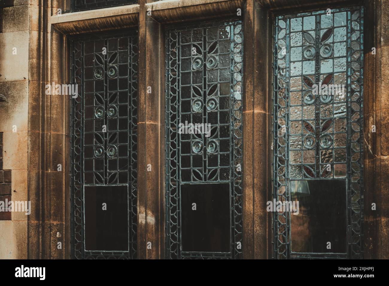 Reich verzierte Buntglasfenster, von Stein eingerahmt, spiegeln die zeitlose Architektur von Cambridge, Großbritannien, wider. Stockfoto