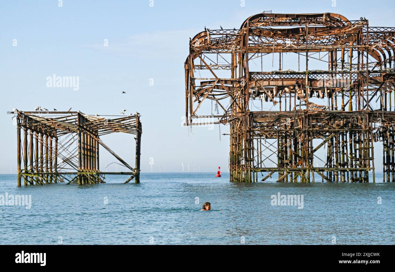 Brighton Großbritannien 19. Juli 2024 - Ein Meeresschwimmer am Brighton West Pier vorbeifährt in der schönen heißen Sonne mit Temperaturen, die in einigen Teilen des Südostens 30 Grad erreichen werden: Credit Simon Dack / Alamy Live News Stockfoto