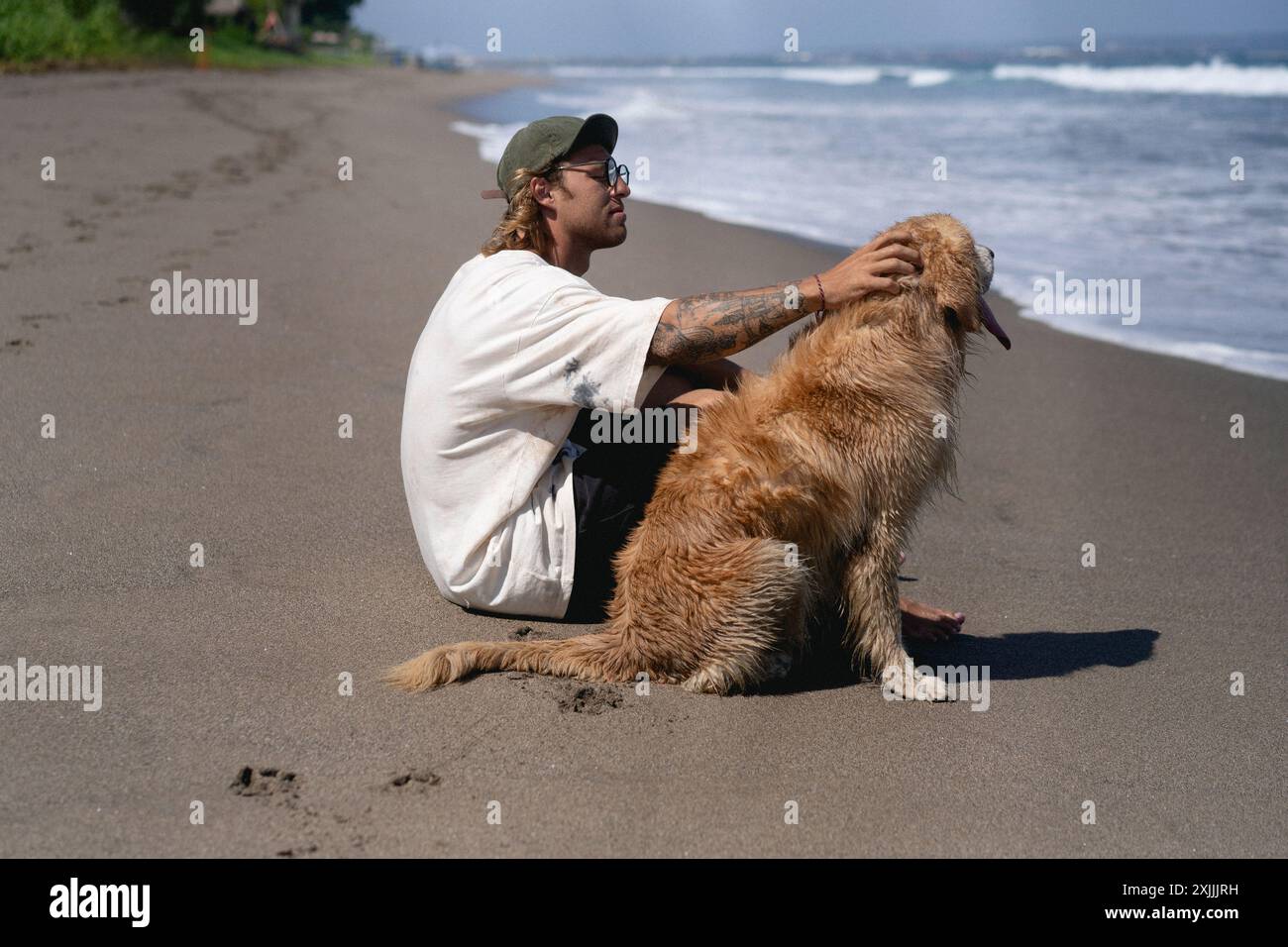 Mann am Strand mit Retriever-Hund. Stockfoto