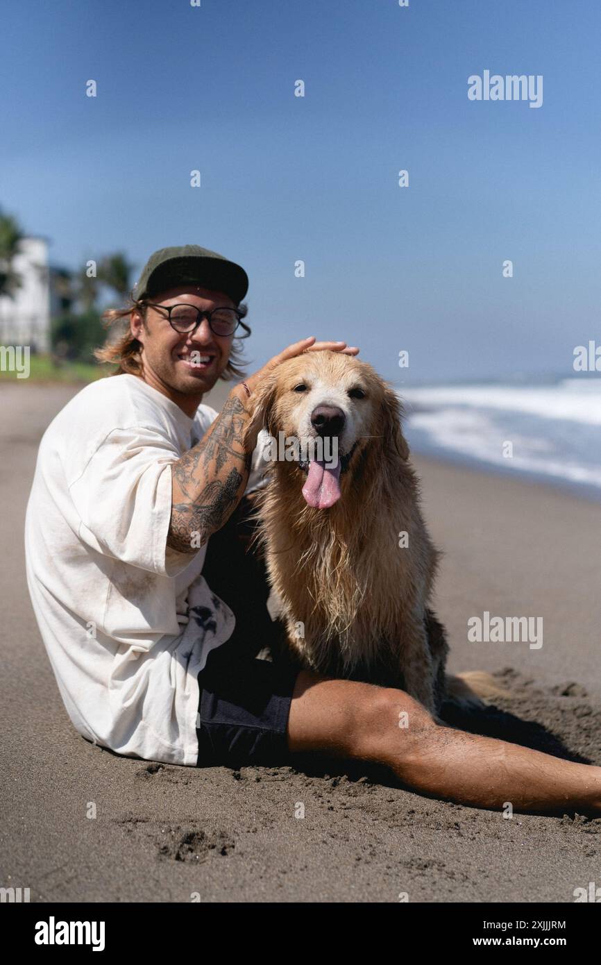 Mann am Strand mit Retriever-Hund. Stockfoto