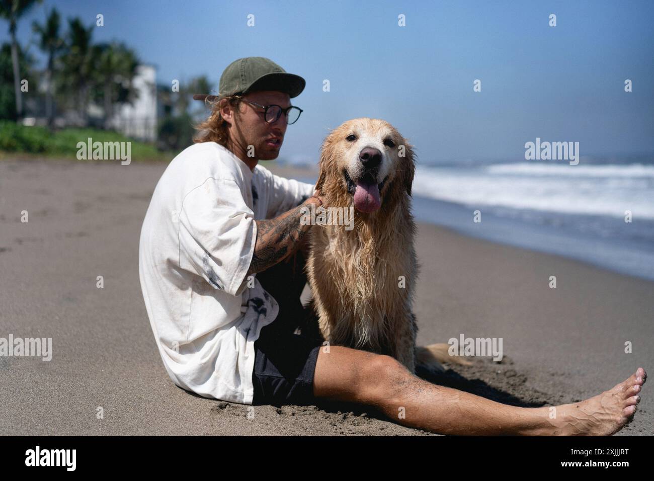 Mann spielt am Strand mit Retriever-Hund. Stockfoto