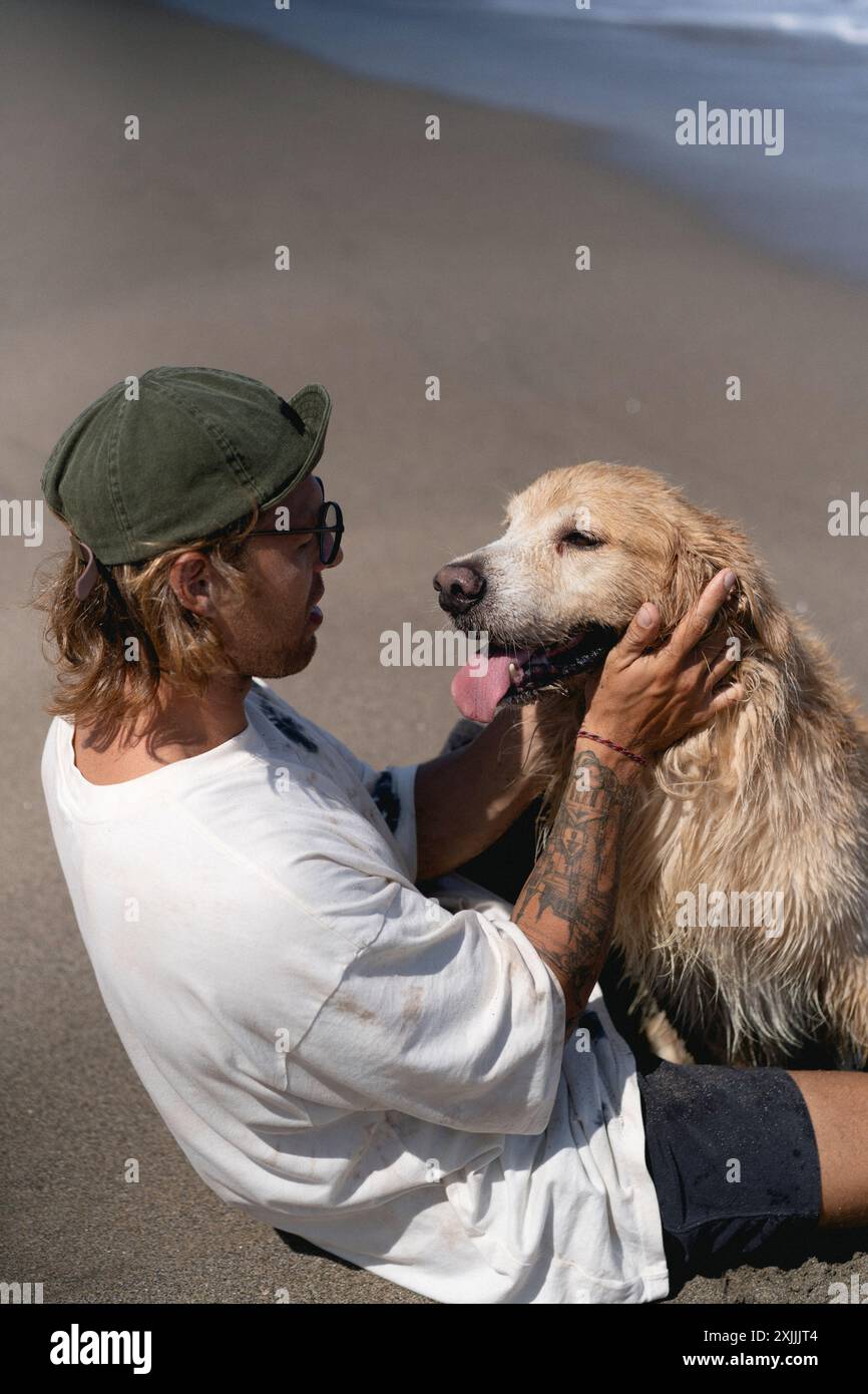 Mann am Strand mit Retriever-Hund. Stockfoto
