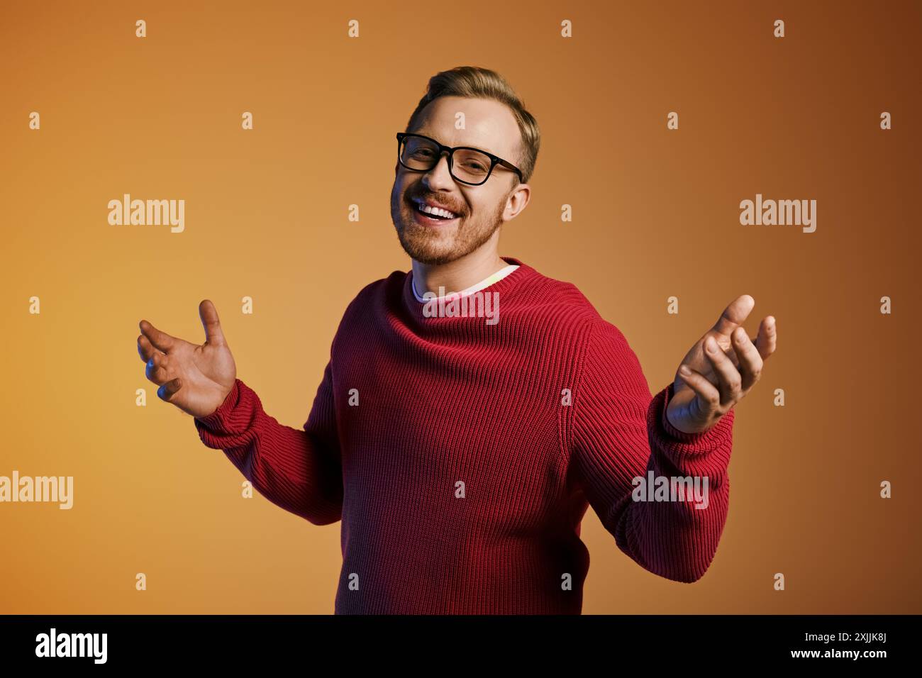 Hübscher Mann mit Brille und rotem Pullover, der selbstbewusst posiert. Stockfoto