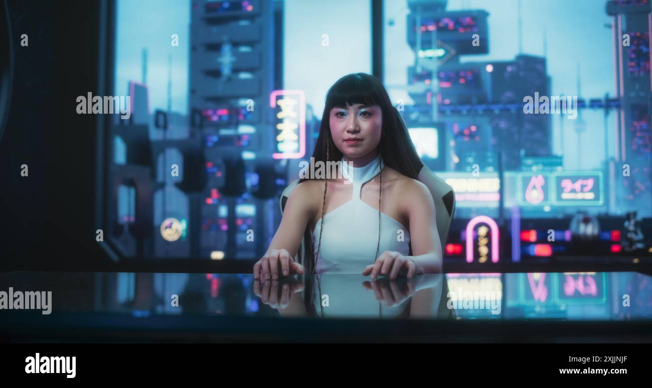 Stilvolle japanische junge Frau, die mit der Augmented-Reality-Plattform in einem technologisch fortschrittlichen Raum interagiert. Sie nutzt Glass Interactive Desk mit Futuristic Cyberpunk City im Hintergrund. Stockfoto