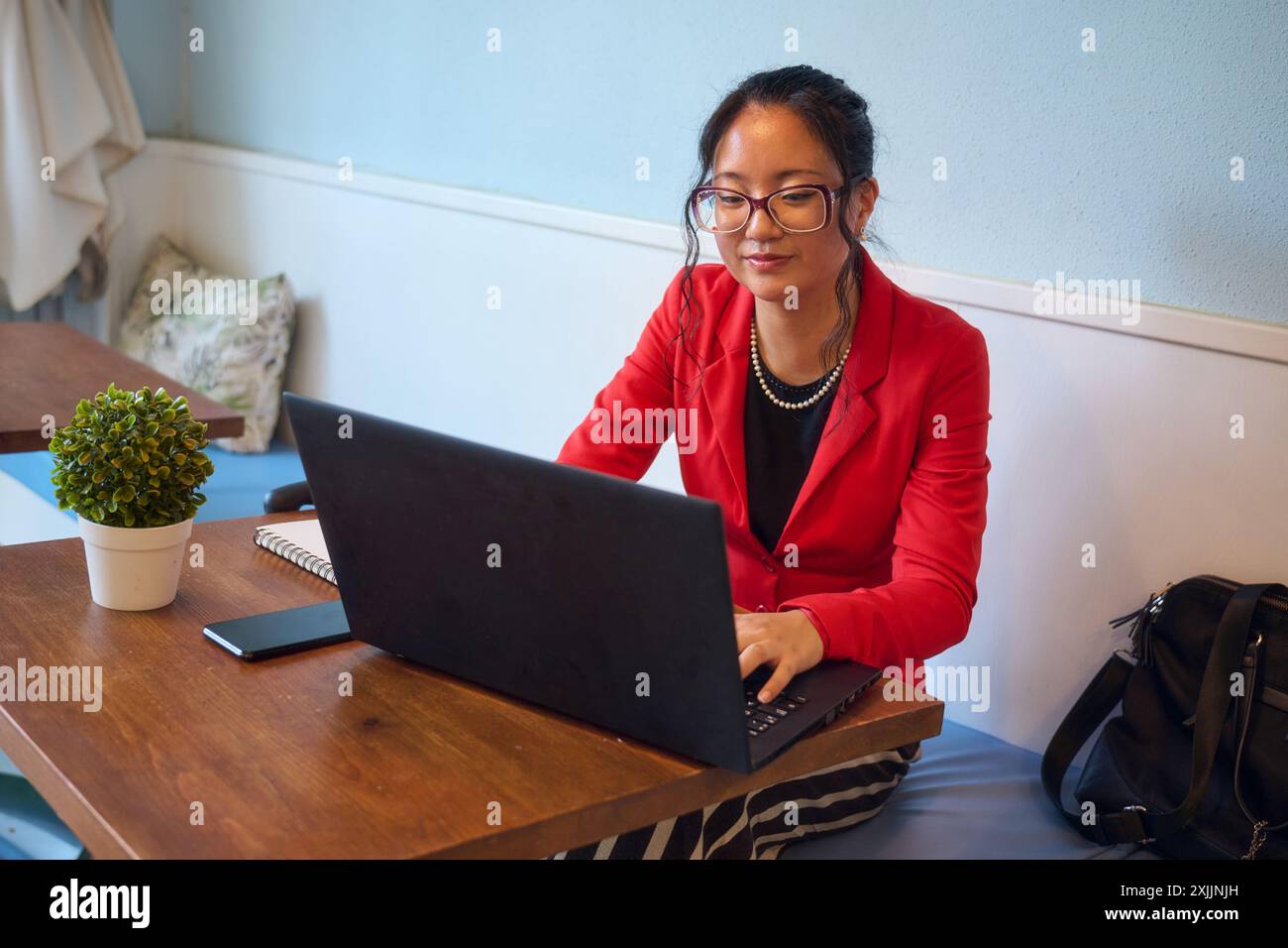 Asiatische Geschäftsfrau arbeitet im Café am Laptop Stockfoto