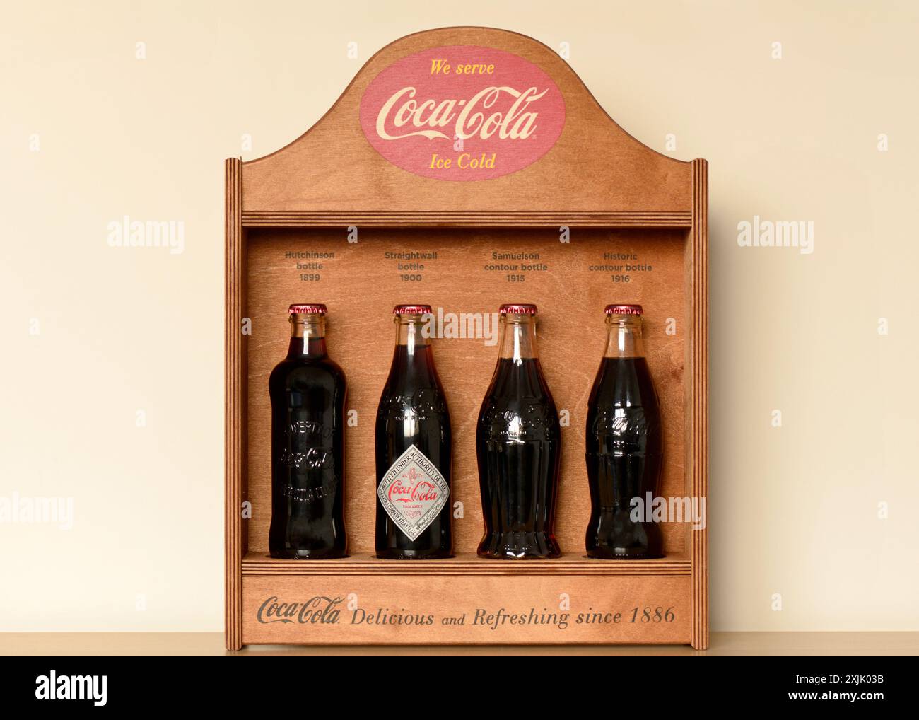 Seltene Vintage-Coca-Cola-Sammlung von Sammlerflaschen mit hölzernem Ausstellungsstand Coca-Cola-Sammlerstücke Stockfoto