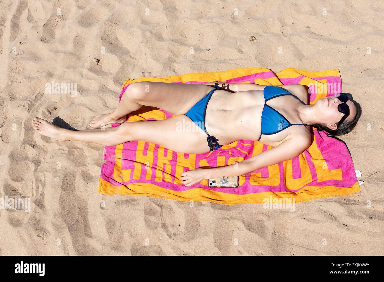 Exmouth, Großbritannien, 11. Juli 2024. Der Sommer ist da! Dana Barbulescu genießt die Sonne am Strand von Exmouth, Devon, Großbritannien. Heute wird der heißeste Tag im Vereinigten Königreich des Jahres bis jetzt sein, mit Temperaturen, die voraussichtlich über 30 Grad erreichen werden… Quelle: Mark Passmore/ Alamy Live News Stockfoto