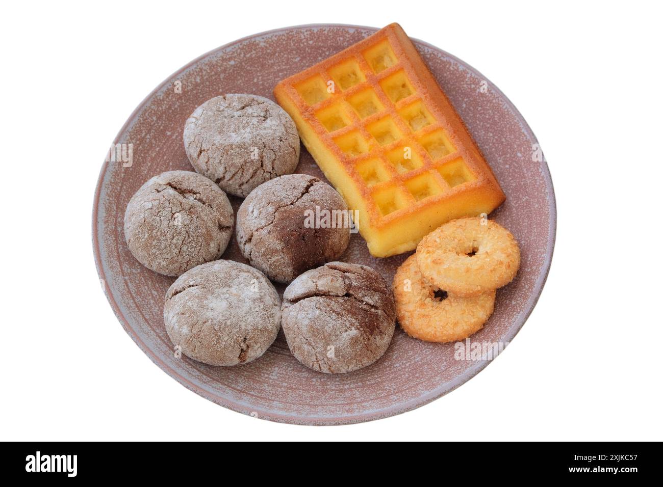 Verschiedene Kuchen und Waffeln in Keramikplatte isoliert auf weißem Hintergrund. Goldener romantischer Keks. Stockfoto