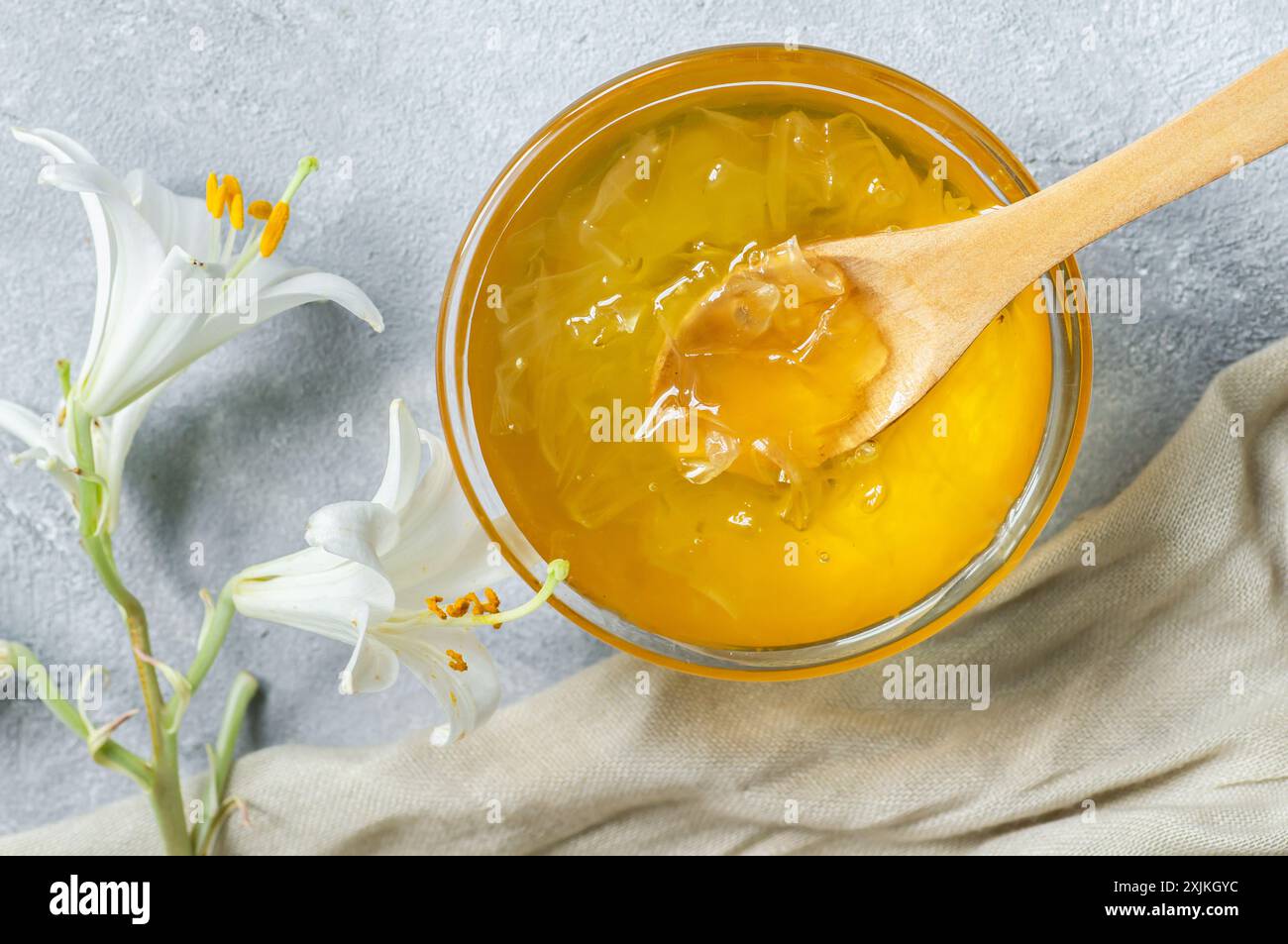 Frische weiße Madonna lilly Marmelade in Glasschale auf weißem rustikalem Tisch Stockfoto