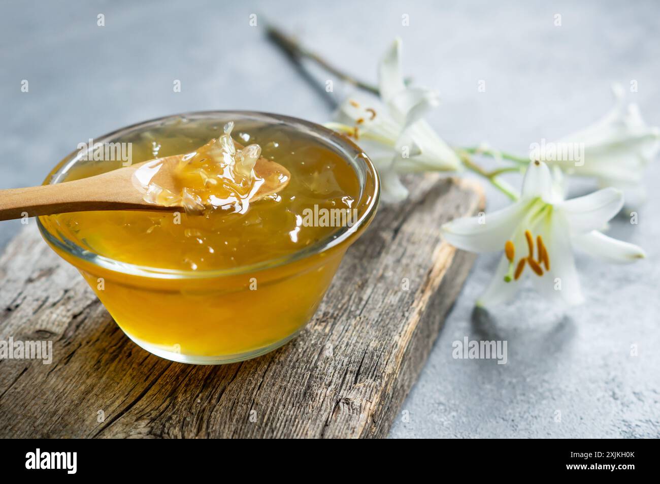 Frische weiße Madonna lilly Marmelade in Glasschale auf weißem rustikalem Tisch Stockfoto