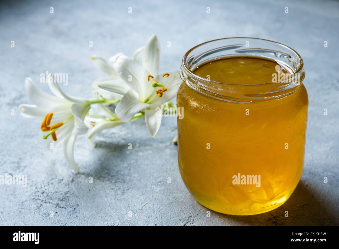 Frische weiße Madonna lilly Marmelade in Glasschale auf weißem rustikalem Tisch Stockfoto