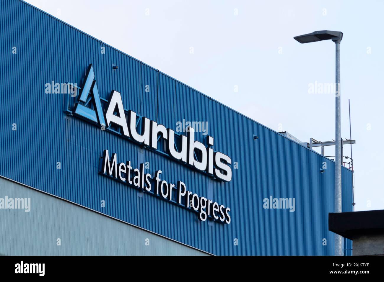 Logo und Schriftzug Aurubis Metal für den Fortschritt in einem Fabrikgebäude im Werk Aurubis AG, Industrieanlage für die Herstellung und das Recycling von Stockfoto