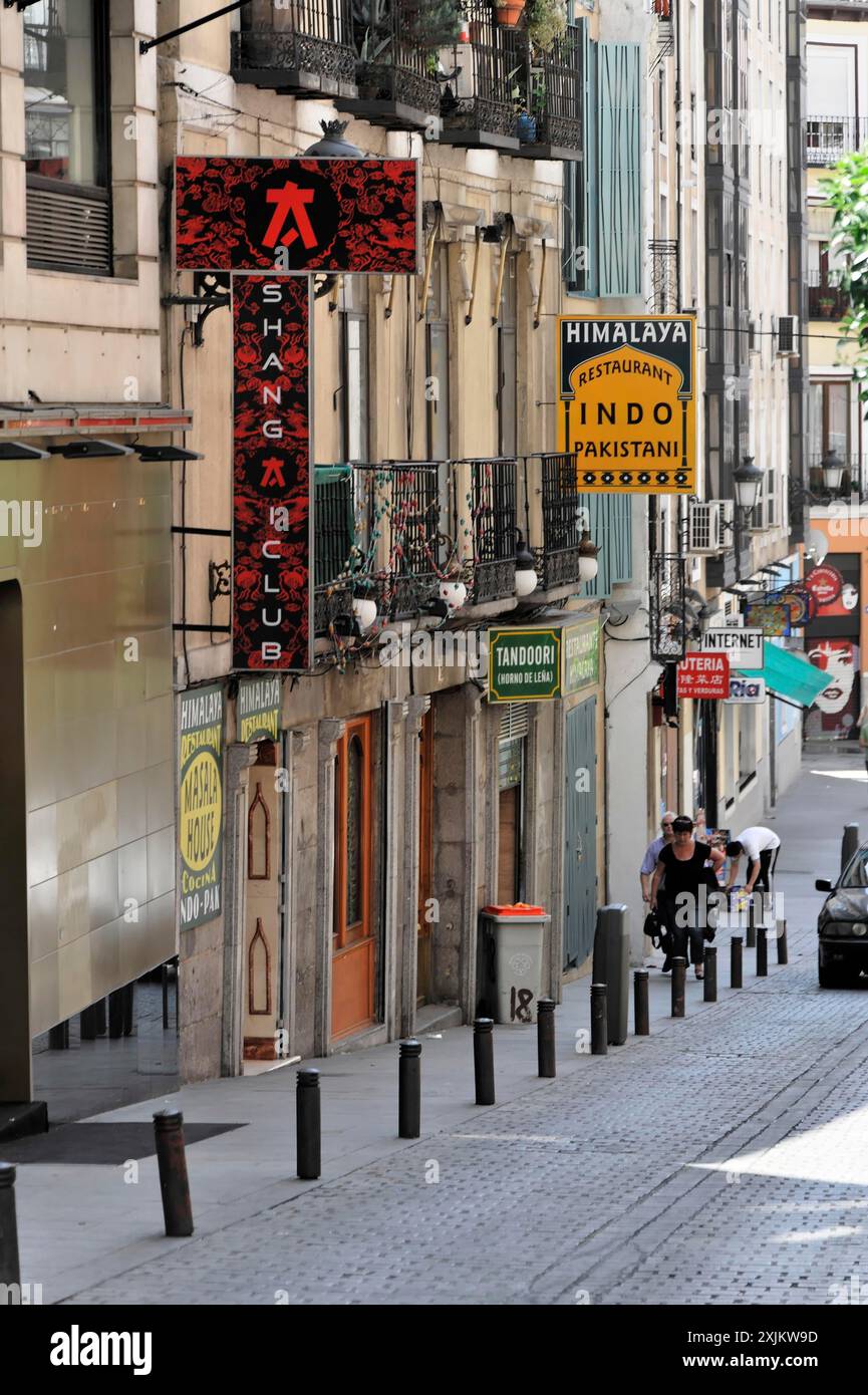 Madrid, Spanien, Europa, Eine enge Straße mit verschiedenen Geschäften und farbenfrohen Schildern, Menschen, die die Straße entlang laufen Stockfoto