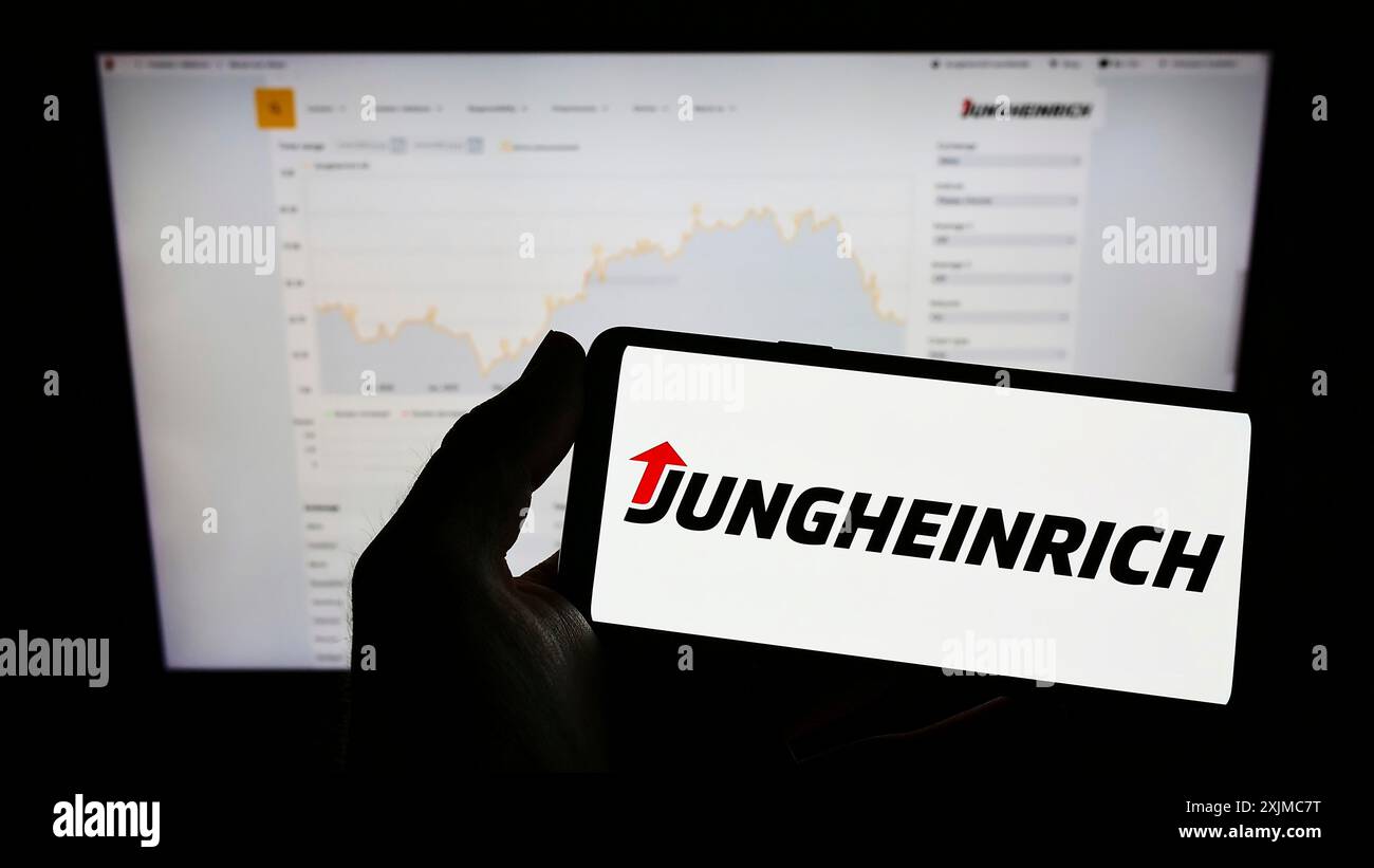Stuttgart, 21.05.2022: Handybesitzer mit Logo des deutschen Maschinenbauunternehmens Jungheinrich AG auf dem Bildschirm vor der Webseite. Stockfoto