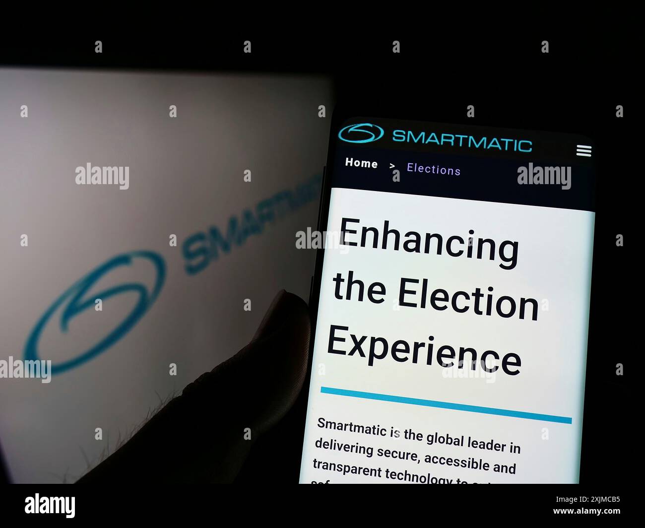 Stuttgart, 21.05.2022: Person, die ein Mobiltelefon hält, mit Webseite der Wahlsystemgesellschaft Smartmatic Corporation auf dem Bildschirm vor dem Logo. Stockfoto