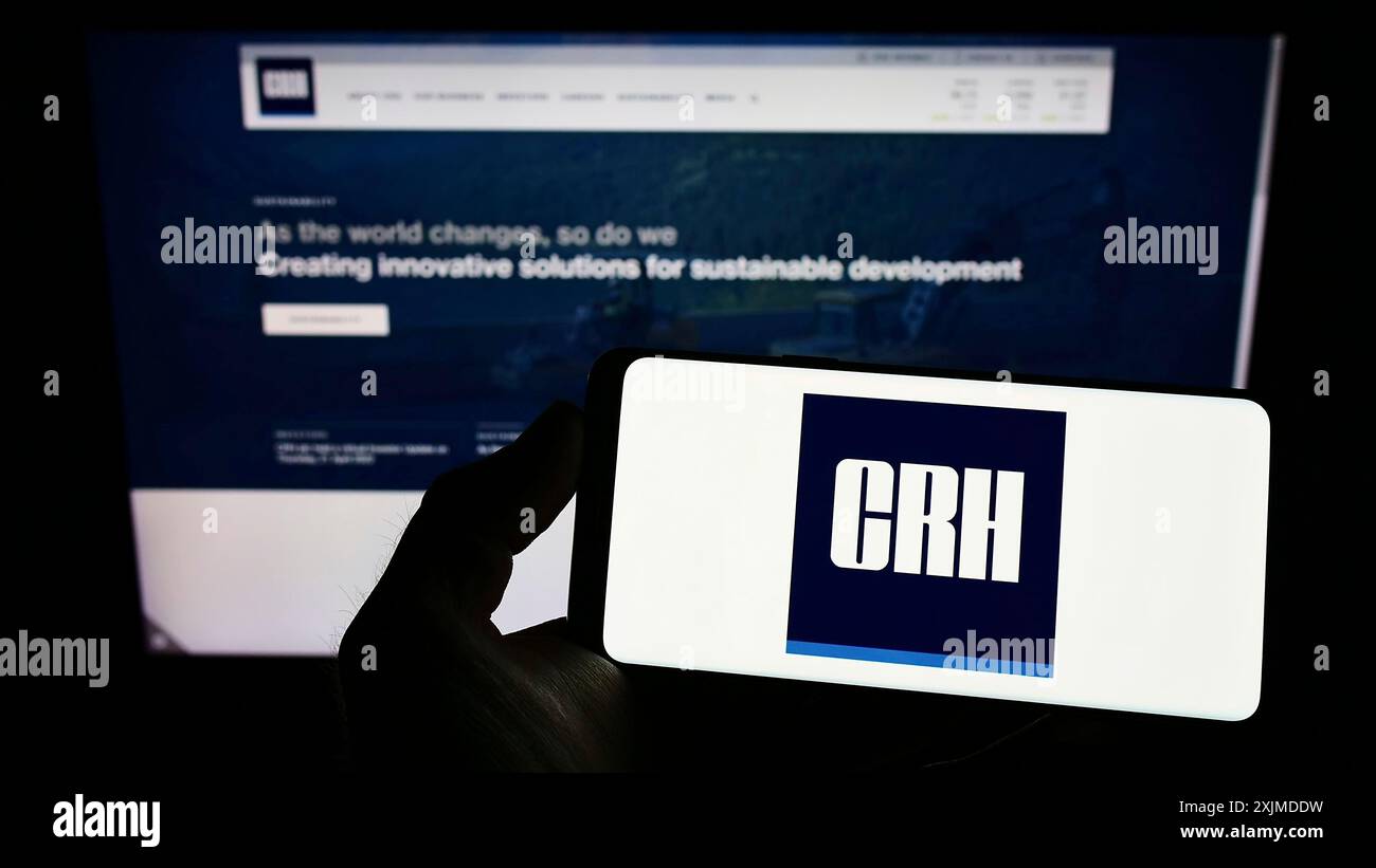 Stuttgart, Deutschland, 29.05.2022: Person, die ein Smartphone mit dem Logo des irischen Baustoffunternehmens CRH plc auf dem Bildschirm vor der Website hält. Fokus Stockfoto