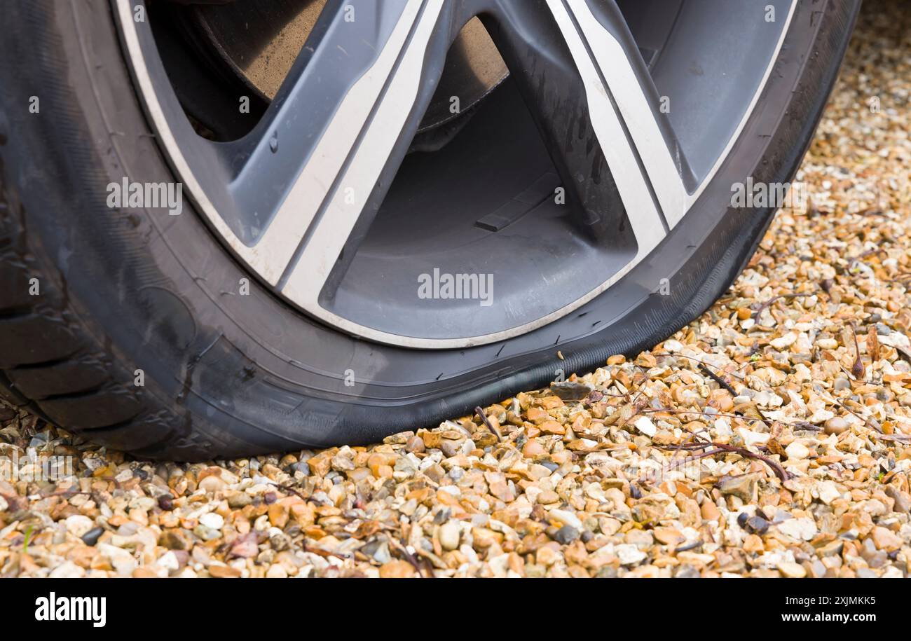Reifenpannen auf einem Autorad. Nahaufnahme eines Fahrzeugrads mit einem Platten Reifen, Reifenpanne. Teil einer Serie von Fotos, die den Wechsel eines Platten Reifens zeigen Stockfoto