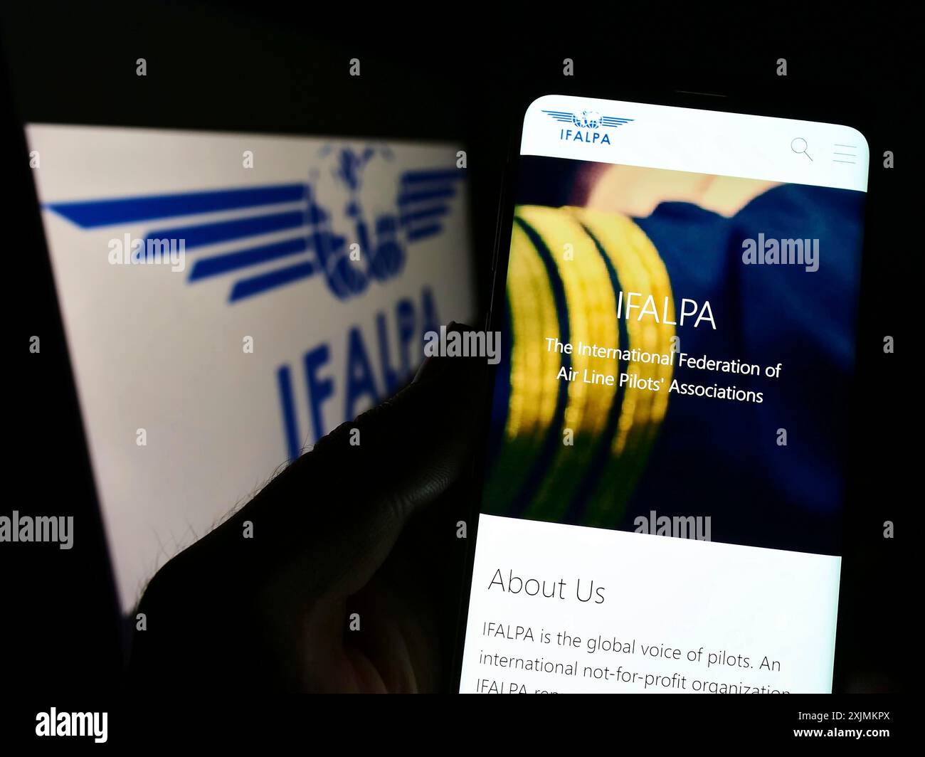 Stuttgart, Deutschland, 09.04.2022: Person, die ein Mobiltelefon hält, mit Website des internationalen Pilotenverbandes IFALPA auf dem Bildschirm vor dem Logo. Fokus Stockfoto