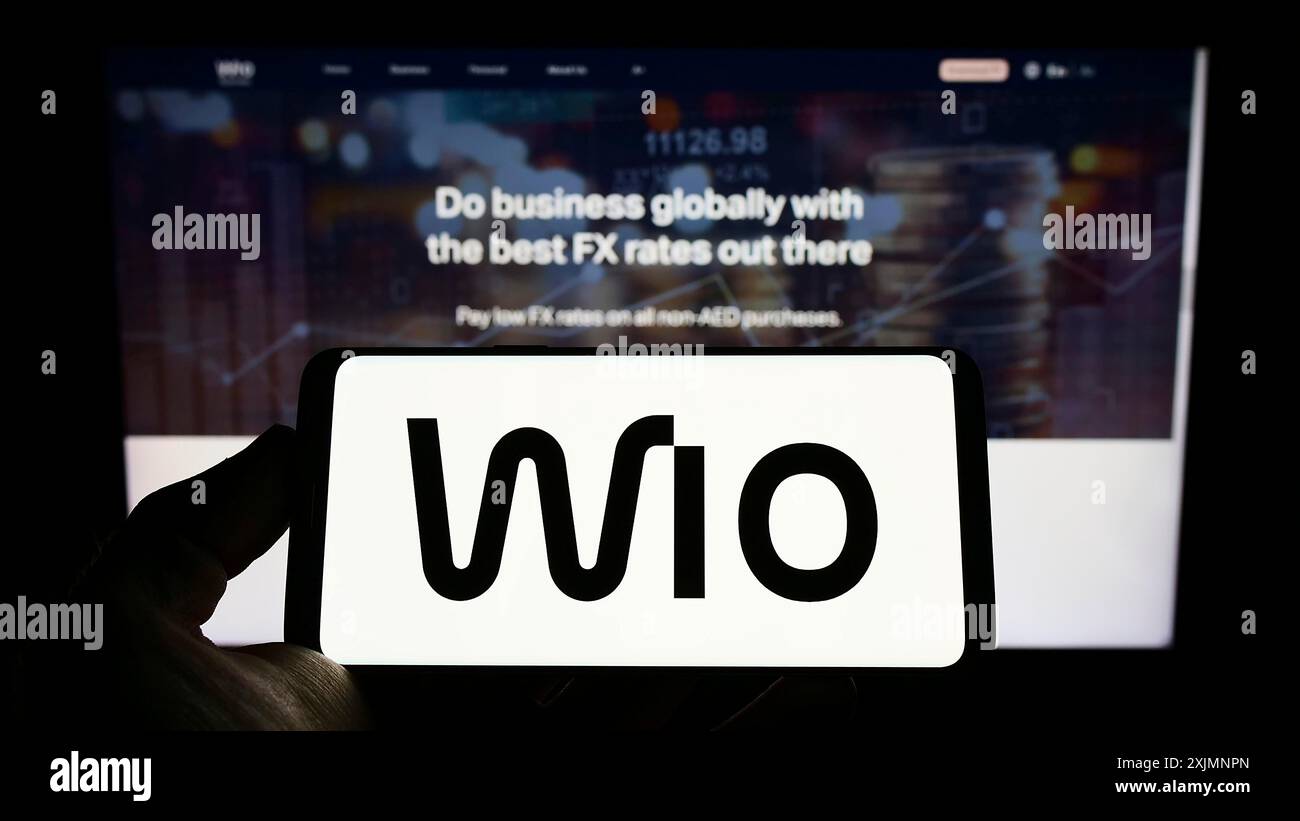 Stuttgart, Deutschland, 19.09.2022: Person, die ein Mobiltelefon mit dem Logo des Finanzdienstleistungsunternehmens Wio Bank PJSC auf dem Bildschirm vor dem Business Web hält Stockfoto