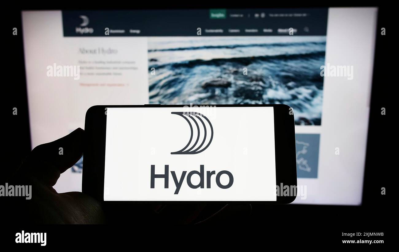 Stuttgart, Deutschland, 22.09.2022: Person, die ein Mobiltelefon mit dem Logo des norwegischen Aluminiumunternehmens Norsk Hydro ASA vor dem Geschäft auf dem Bildschirm hält Stockfoto