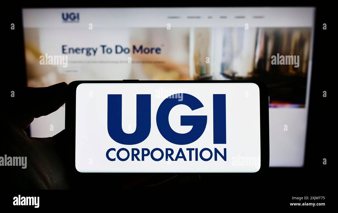 Stuttgart, 18.10.2022: Person, die ein Mobiltelefon hält, mit dem Logo des US-Energieunternehmens UGI Corporation auf dem Bildschirm vor der Unternehmenswebseite. Fokus Stockfoto