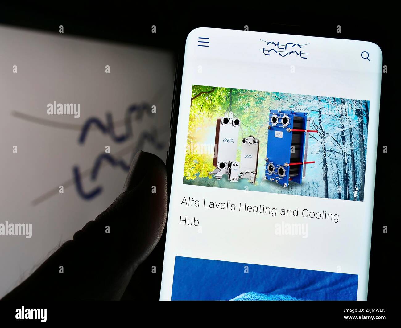 Stuttgart, Deutschland, 12.01.2022: Person, die ein Mobiltelefon hält, mit Webseite des schwedischen Unternehmens Alfa Laval ab auf dem Bildschirm vor dem Firmenlogo. Konzentrieren Sie sich auf Stockfoto