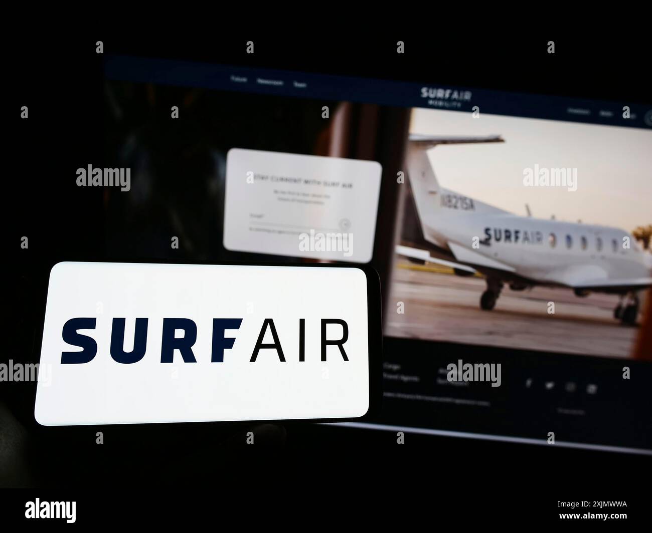 Stuttgart, Deutschland, 12.04.2022: Person, die ein Mobiltelefon mit dem Logo des amerikanischen Luftfahrtunternehmens Surf Air Mobility auf dem Bildschirm vor der Webseite hält. Stockfoto