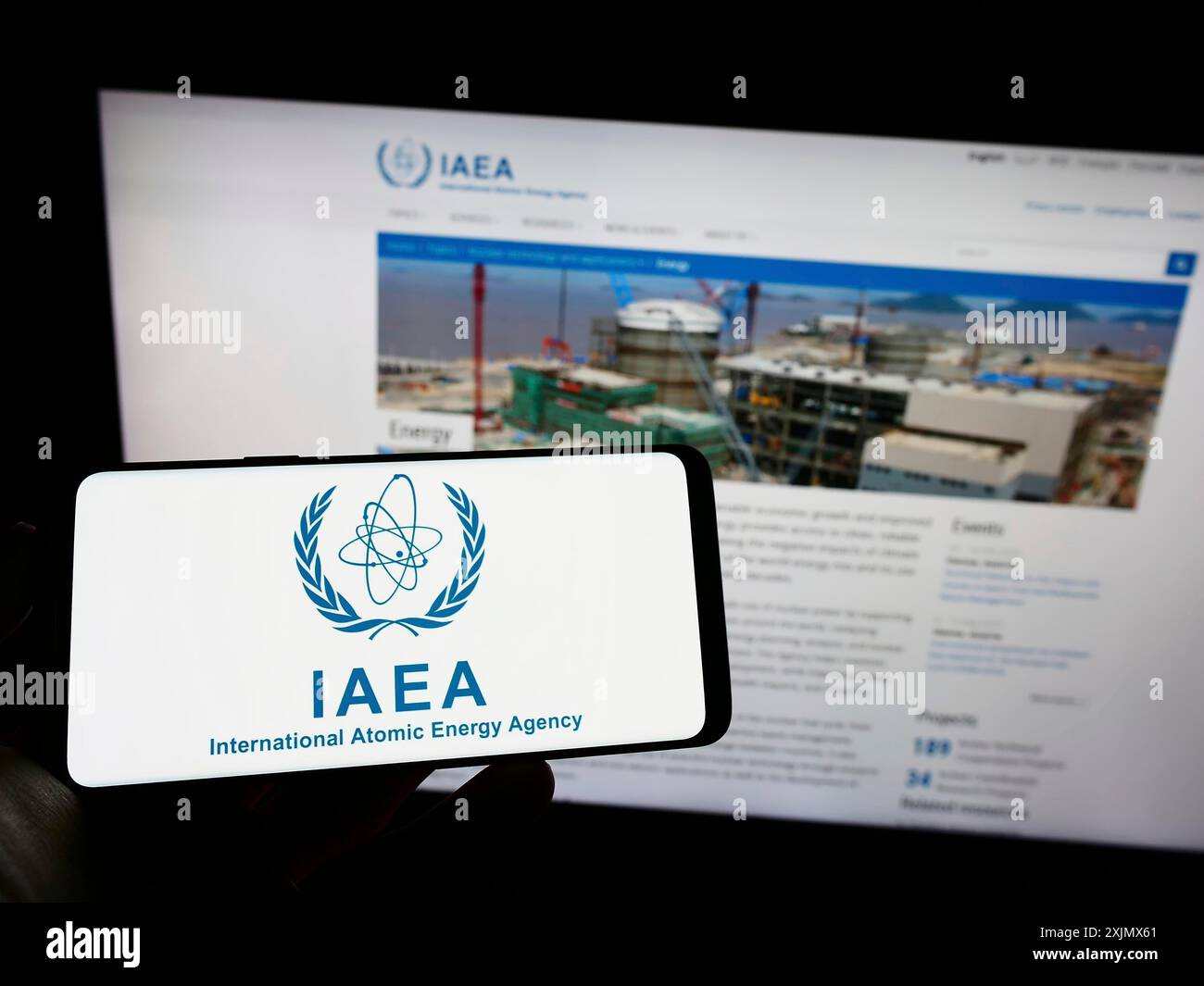 Stuttgart, Deutschland, 12.10.2022: Person, die ein Mobiltelefon mit dem Logo der Internationalen Atomenergie-Organisation (IAEO) auf dem Bildschirm vor der Webseite hält. Fokus Stockfoto
