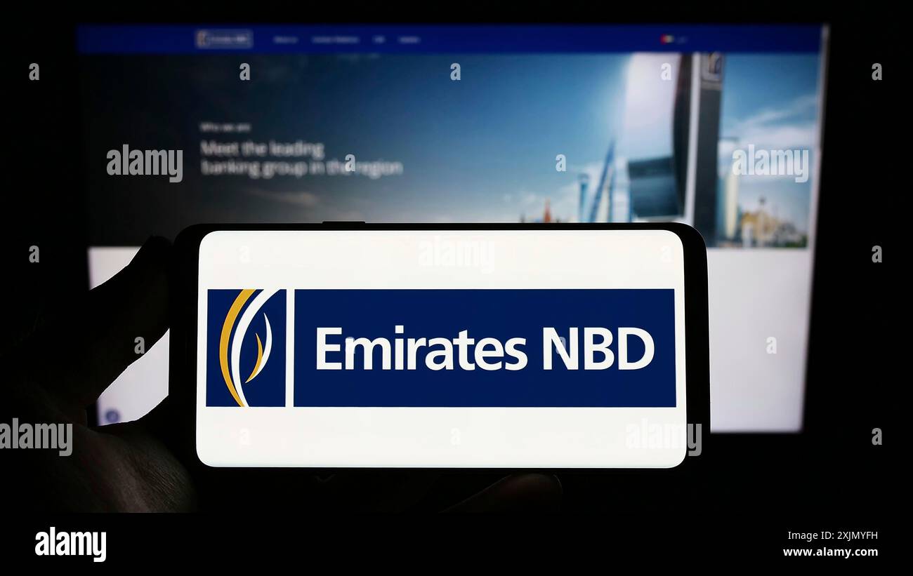 Stuttgart, Deutschland, 01.07.2023: Person mit Smartphone und Logo des Finanzunternehmens Emirates NBD Bank PJSC auf dem Bildschirm vor der Website. Fokus Stockfoto