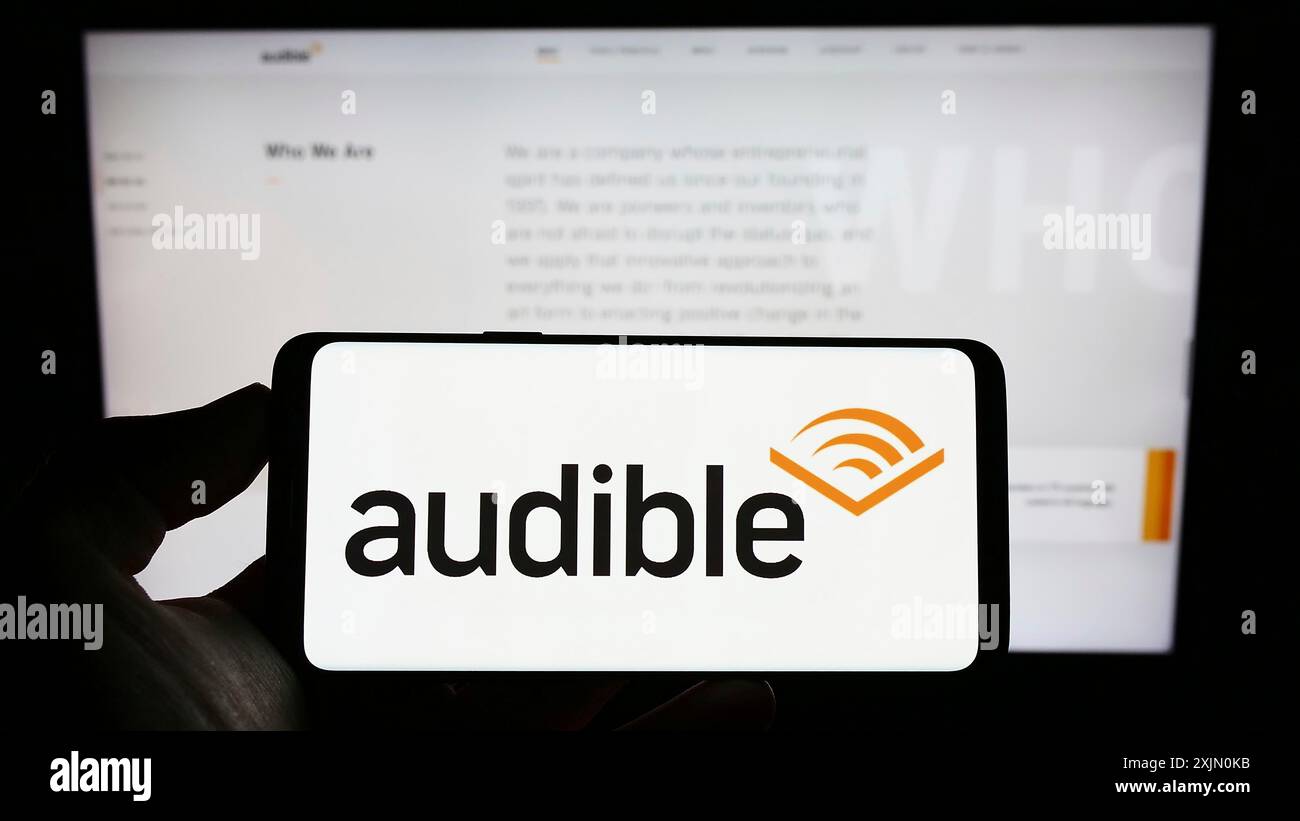 Stuttgart, Deutschland, 14.01.2023: Person, die ein Mobiltelefon mit dem Logo des US-amerikanischen Hörbuchunternehmens Audible Inc. Auf dem Bildschirm vor der Unternehmenswebseite hält. Fokus Stockfoto